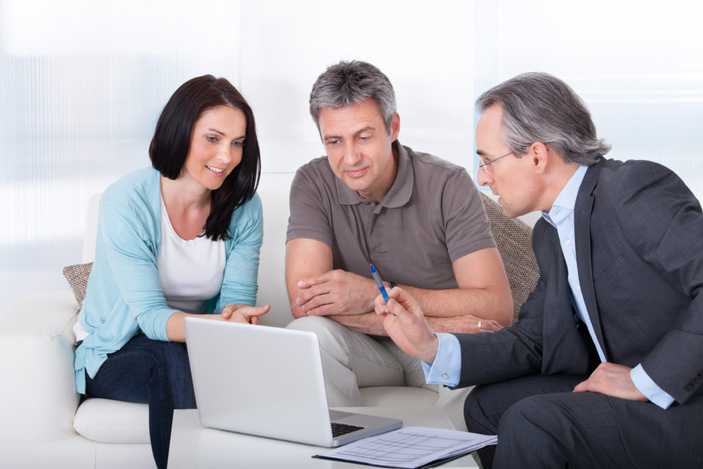 Happy Couple And Mature Consultant Discussing Together